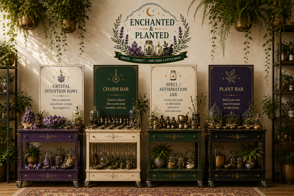 A styled indoor scene showing four decorative cart-like stands labeled Crystal Intention Bowl, Charm Bar, Spell / Affirmation Jar, and Plant Bar, arranged beneath a large sign reading Enchanted & Planted. The setup includes plants, jars, crystals, and decorative props in a warm, rustic room.